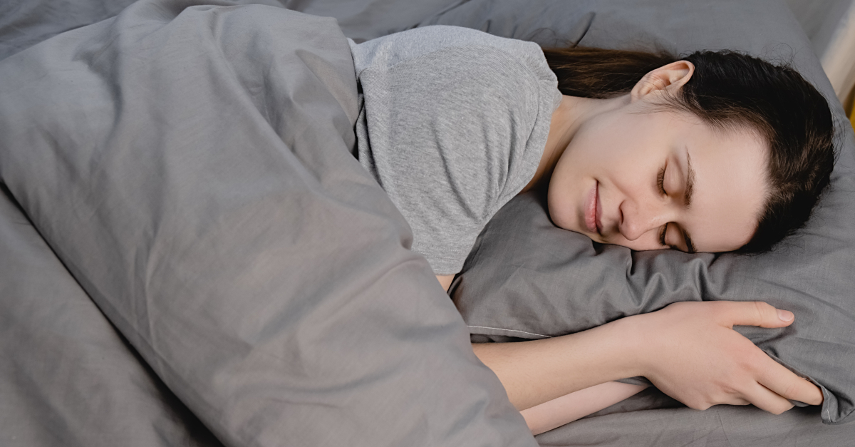 woman asleep in gray bedcovers