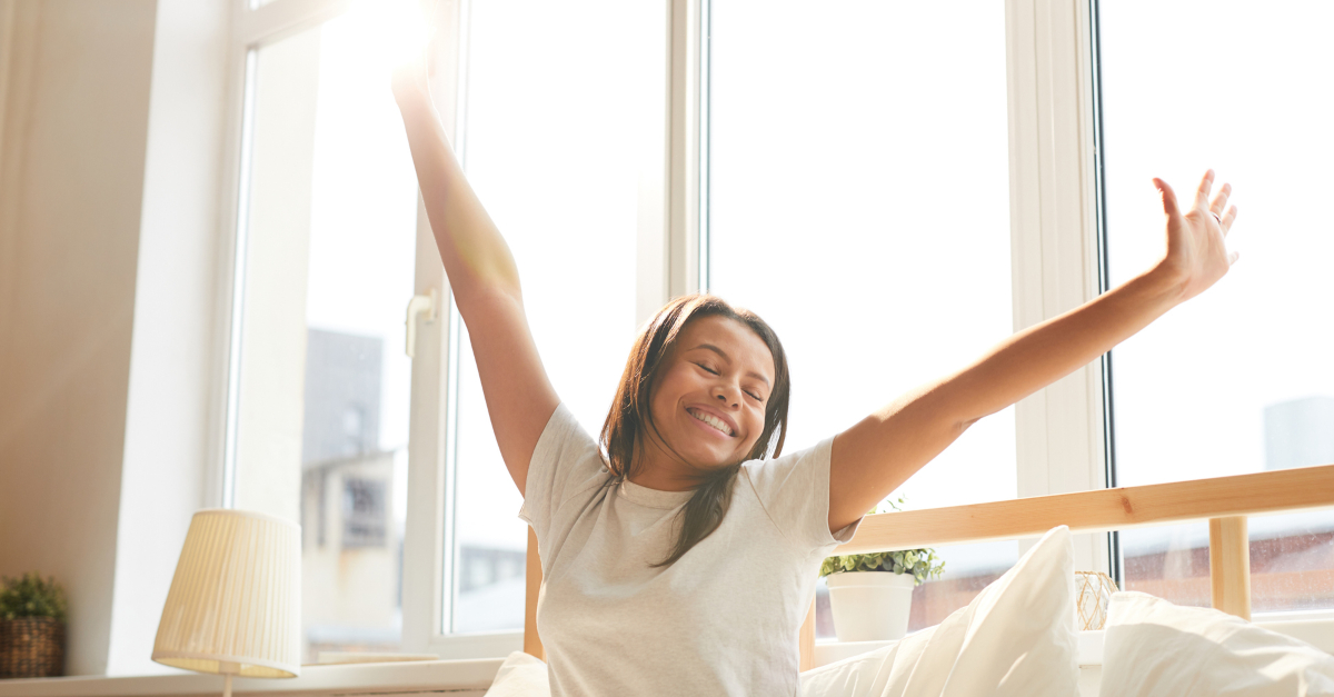 woman waking up in minimalist home joyful