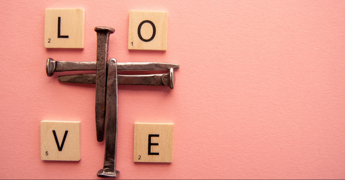 nails in shape of a cross with scrabble tiles spelling love