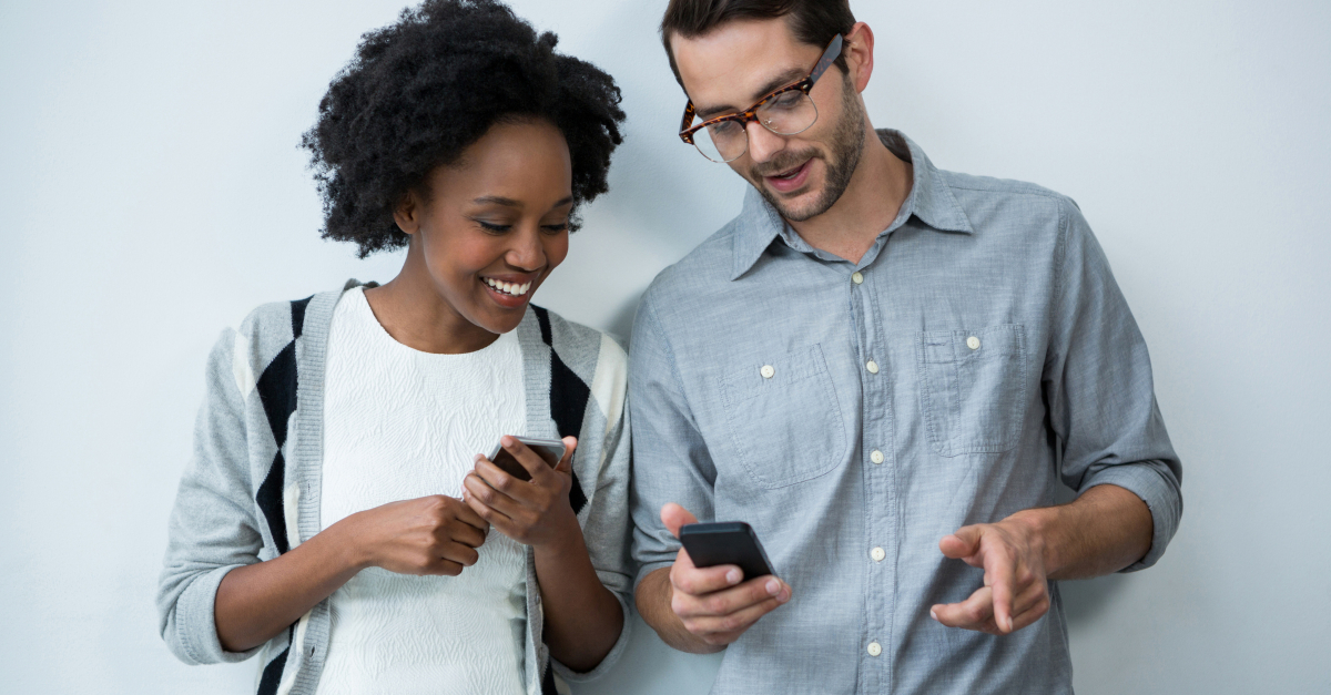 man and woman smiling at cell phone looking at social media Instagram