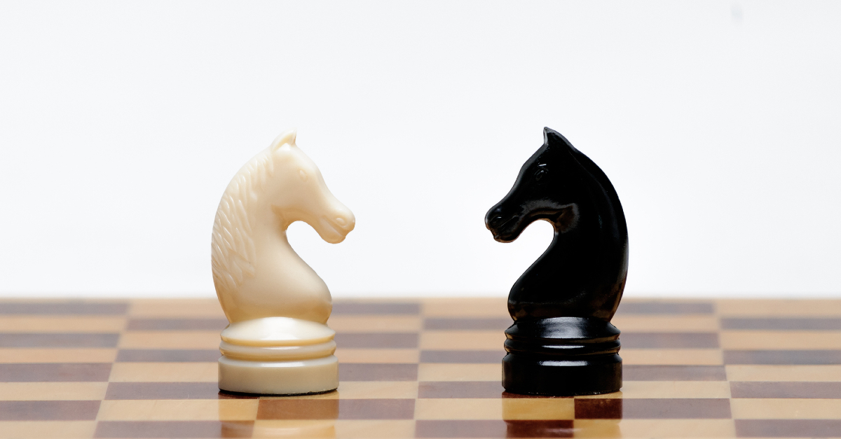 black and white chess pieces on chess board facing eachother