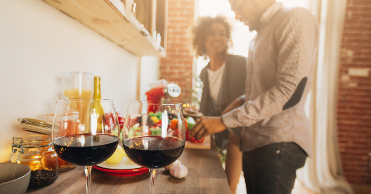 couple prepping dinner together two glasses red wine in foreground, should christians drink