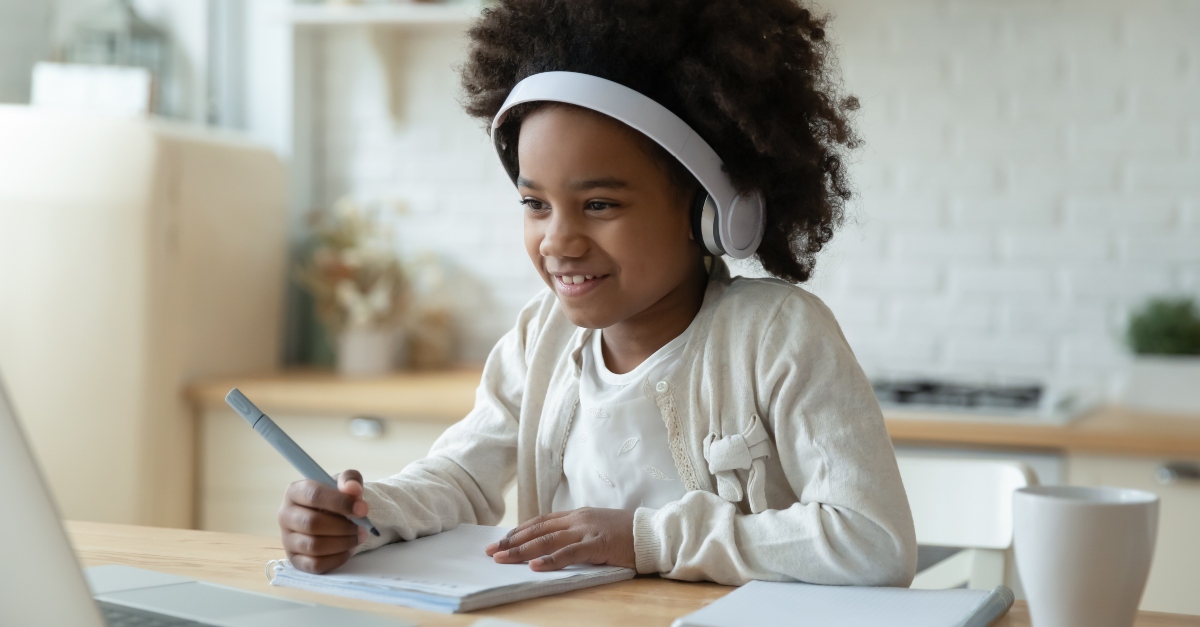 Young girl doing schoolwork on a laptop-Online Christian Homeschool Programs