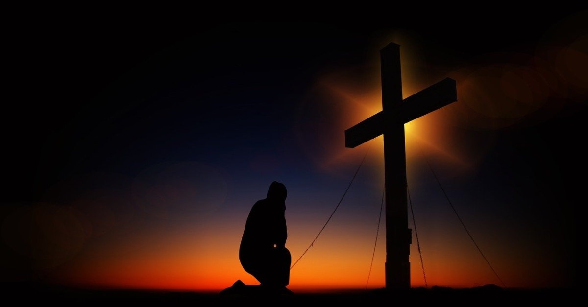 Man kneeling before the cross
