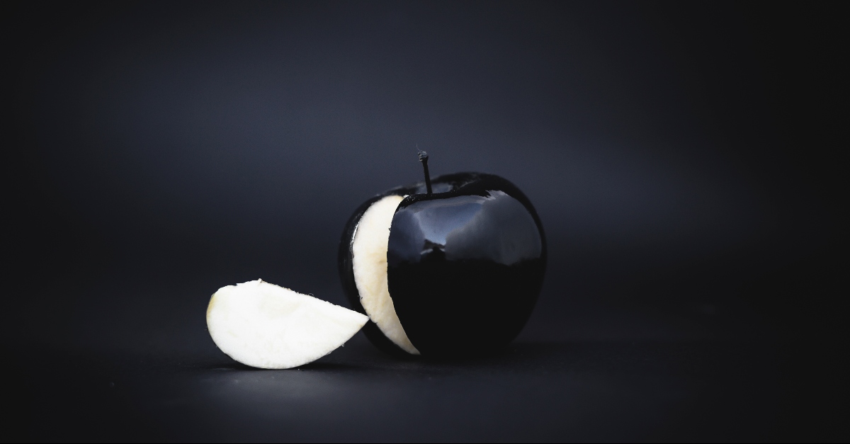 A black apple with a black background
