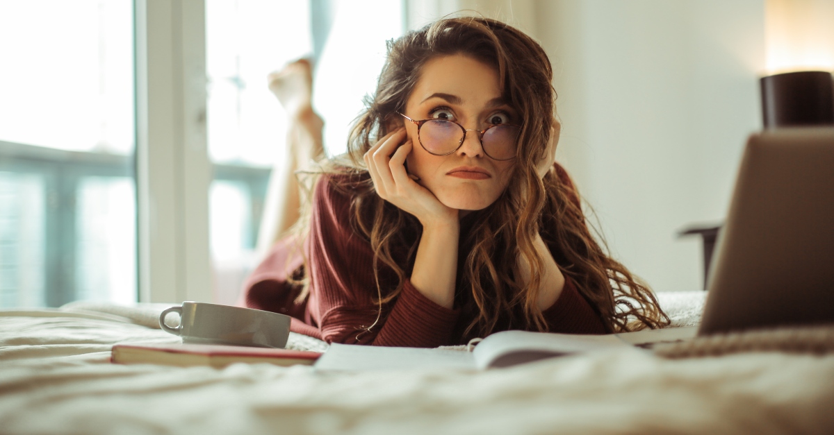 woman laying on bed with computer looking perplexed making silly face, ways quiet time with god needs to change