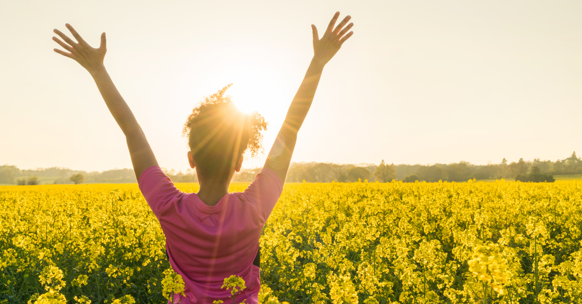 donna braccia in lode celebrazione gratitudine nel campo wildflower