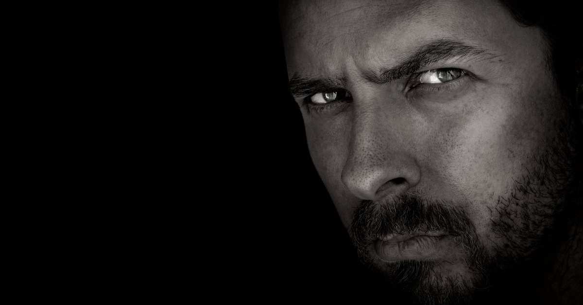 sinister and serious close up of man's expression in black and white