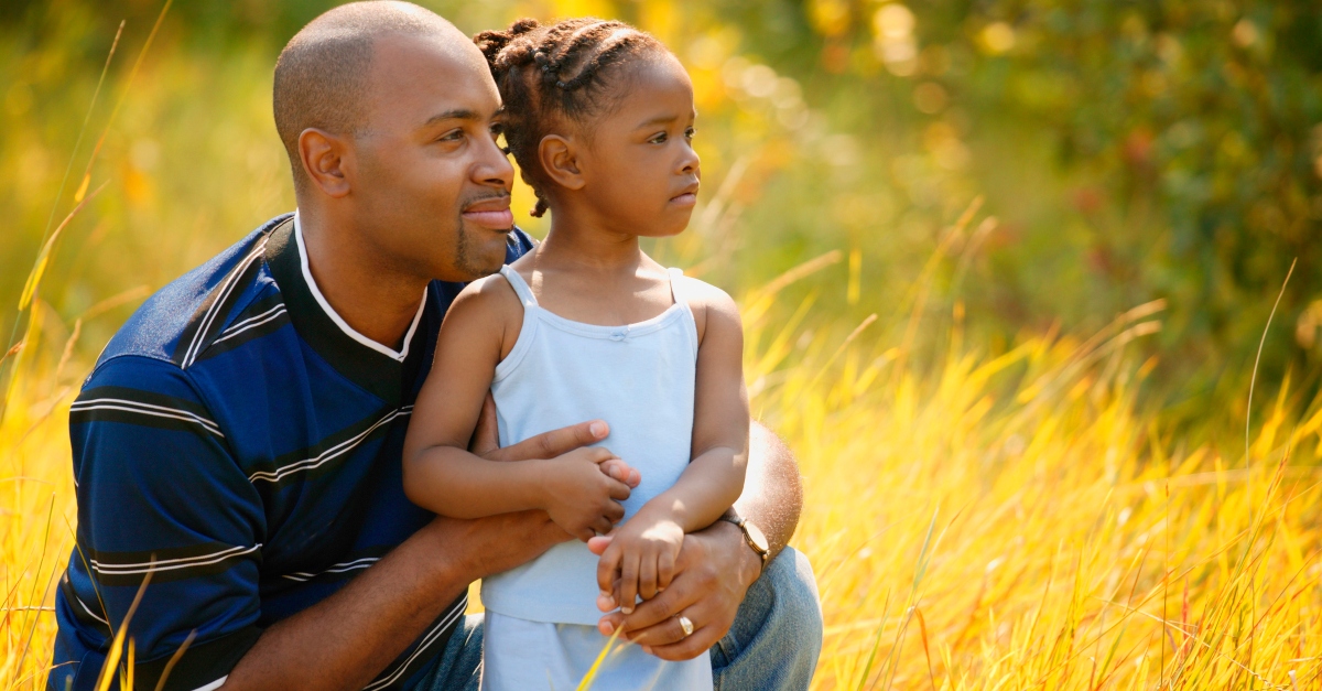 Dad and daughter in yellow field looking forward visioning future