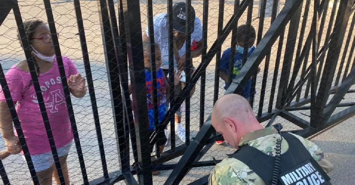 A National Guard Member praying with a child, 5-year-old boy prays with a National Guard member amid protests