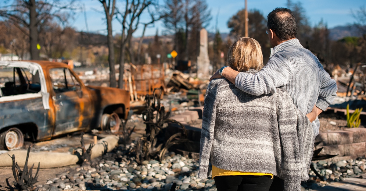 adult couple standing looking at burned house, prayer for california fires