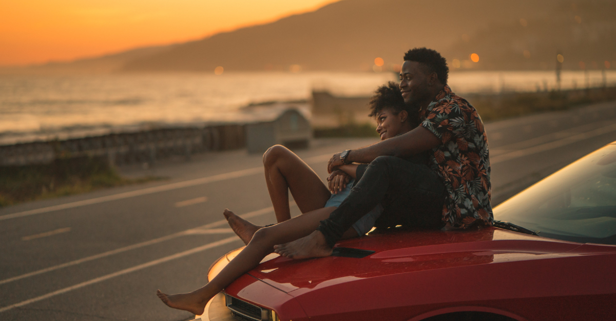 couple looking at a sunset by the mountains