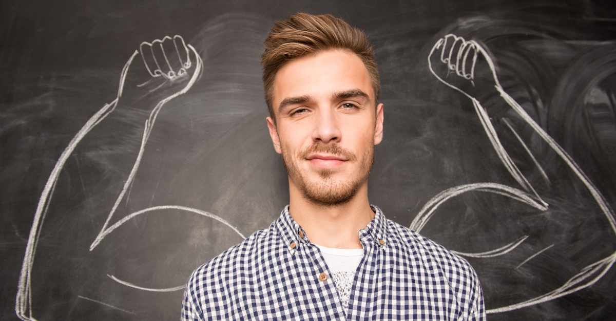 Young man with muscles drawn on the wall behind him, strong