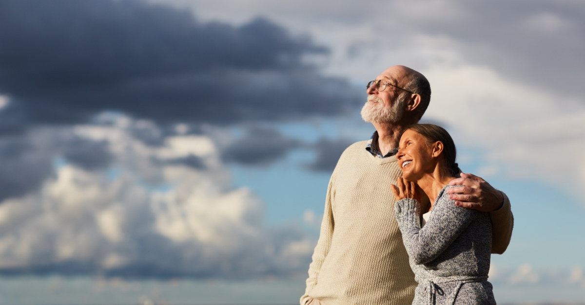 Peaceful senior couple gazing at sunset