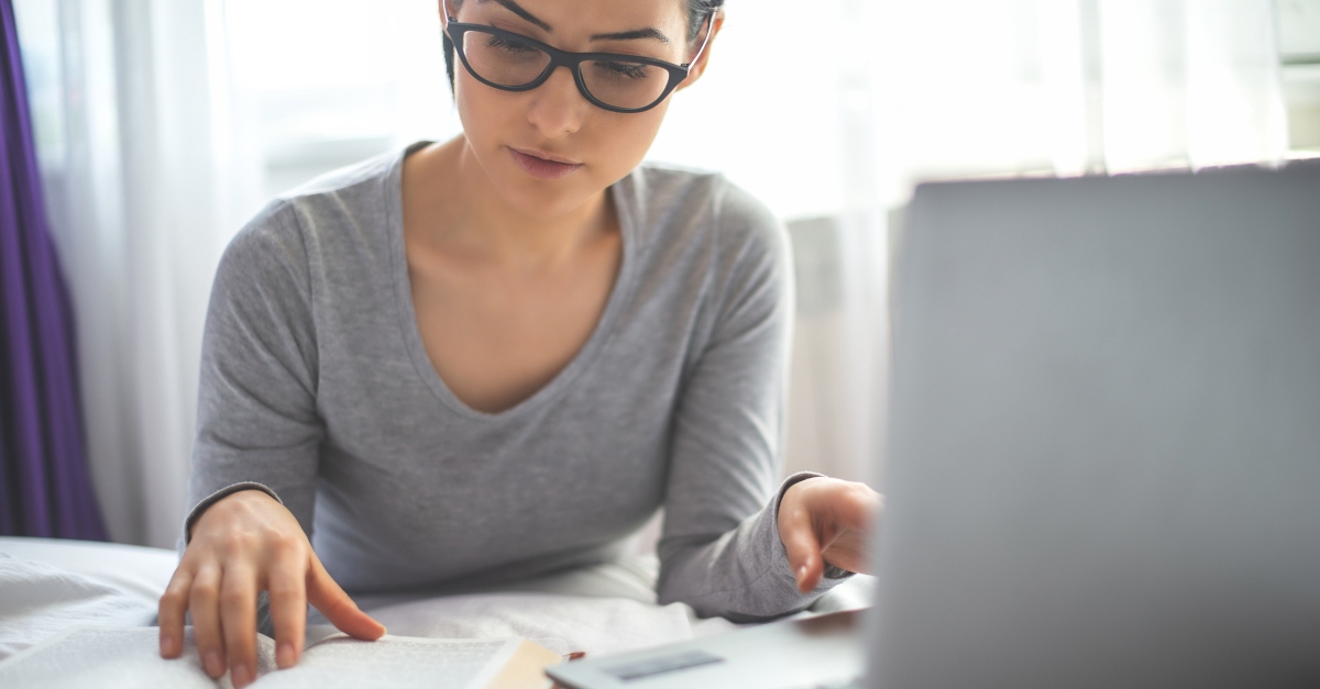 woman on laptop with smartphone and Bible