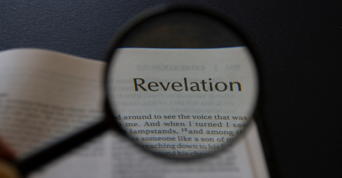 bible open to revelation with magnifying glass