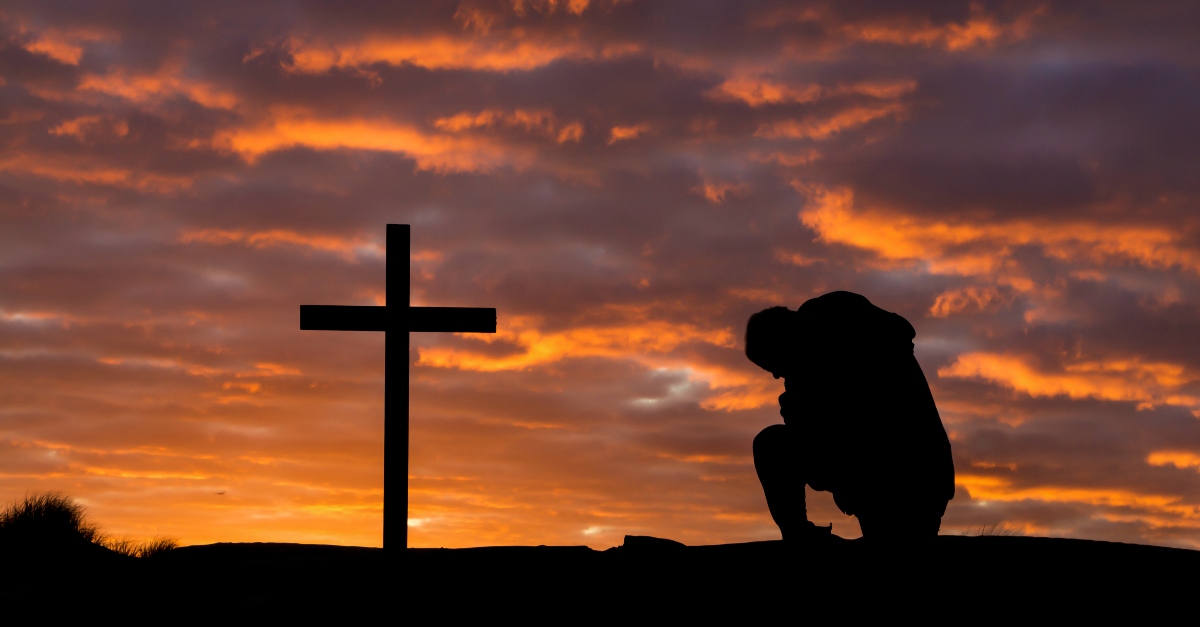 Man kneeling before the cross
