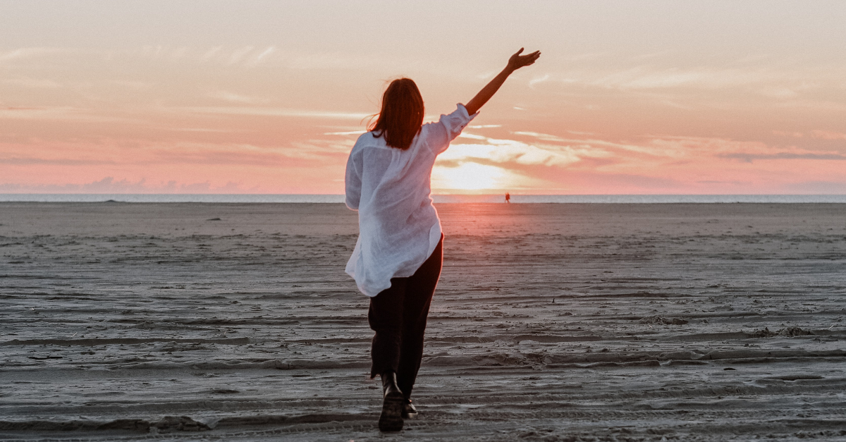 woman walking on empty beach praising, pray without ceasing