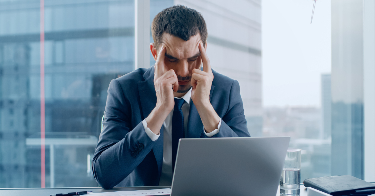 overworked man stressed out at laptop