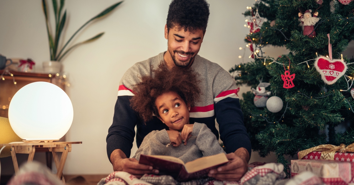 Dad and daughter reading together at Christmas