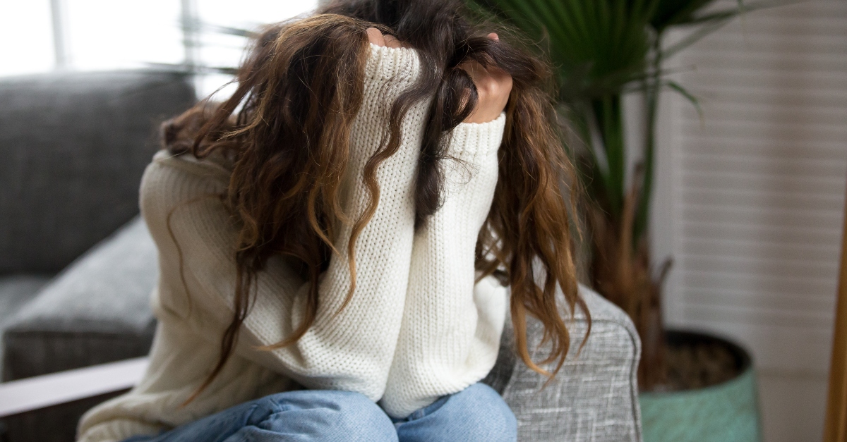 woman hiding in sweater looking afraid and worried, prayers for moments of anxiety