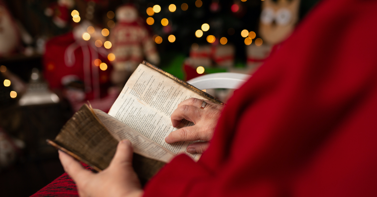 Person reading a Bible near a Christmas tree, things to notice when you read Luke 2
