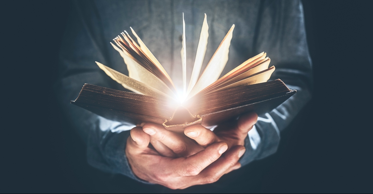 Bible glowing in a mans hands