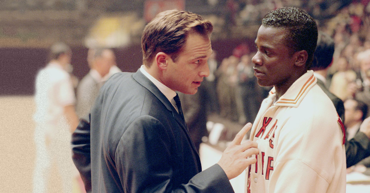 A Basketball coach talking to a player during a game