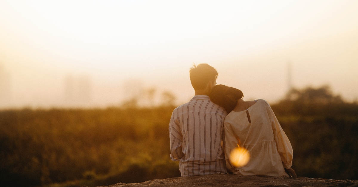 couple sitting together watching sunset, how to heal after miscarriage