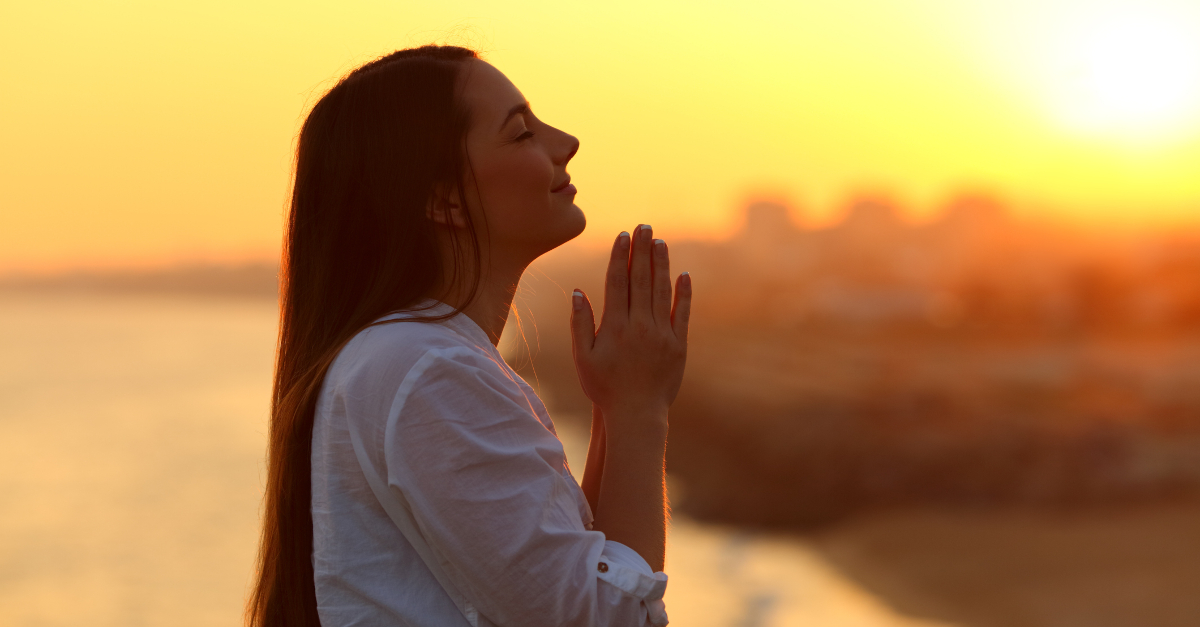 Woman praying outside under sunset, prayer for pastor