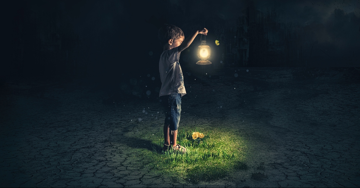 Boy holding a lantern in the dark