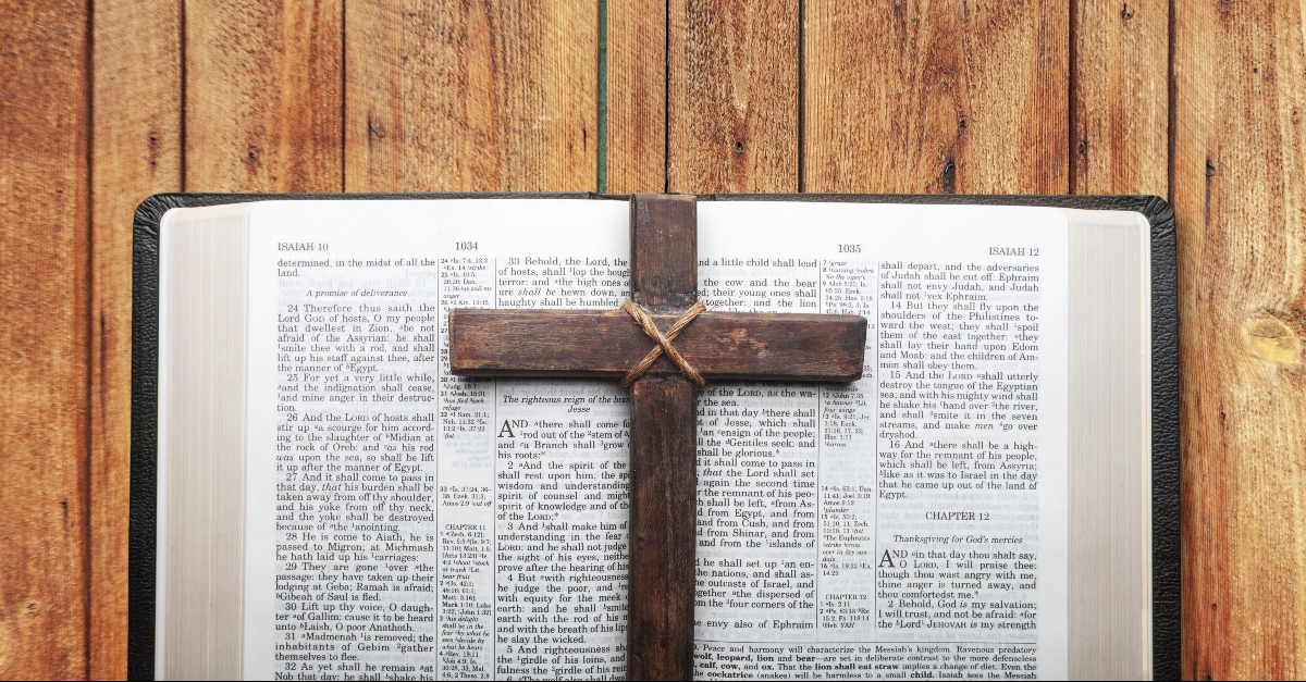 A wooden cross on a Bible