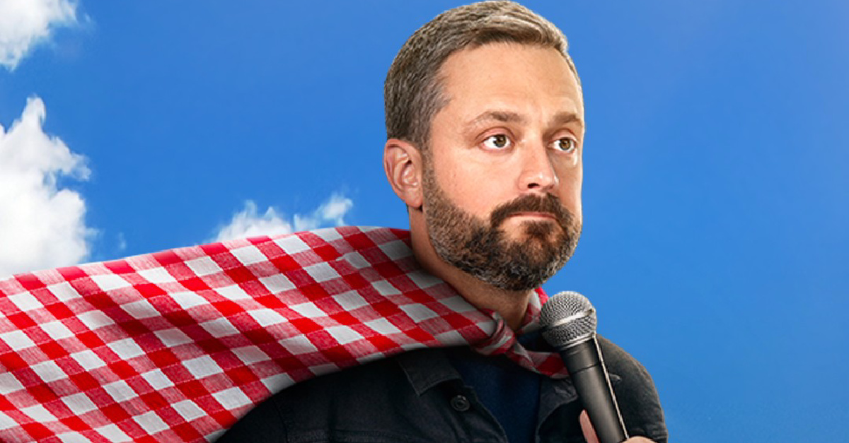 Nate Bargatze wearing a tablecloth cape and holding a microphone