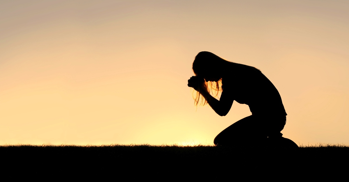 man praying on knees