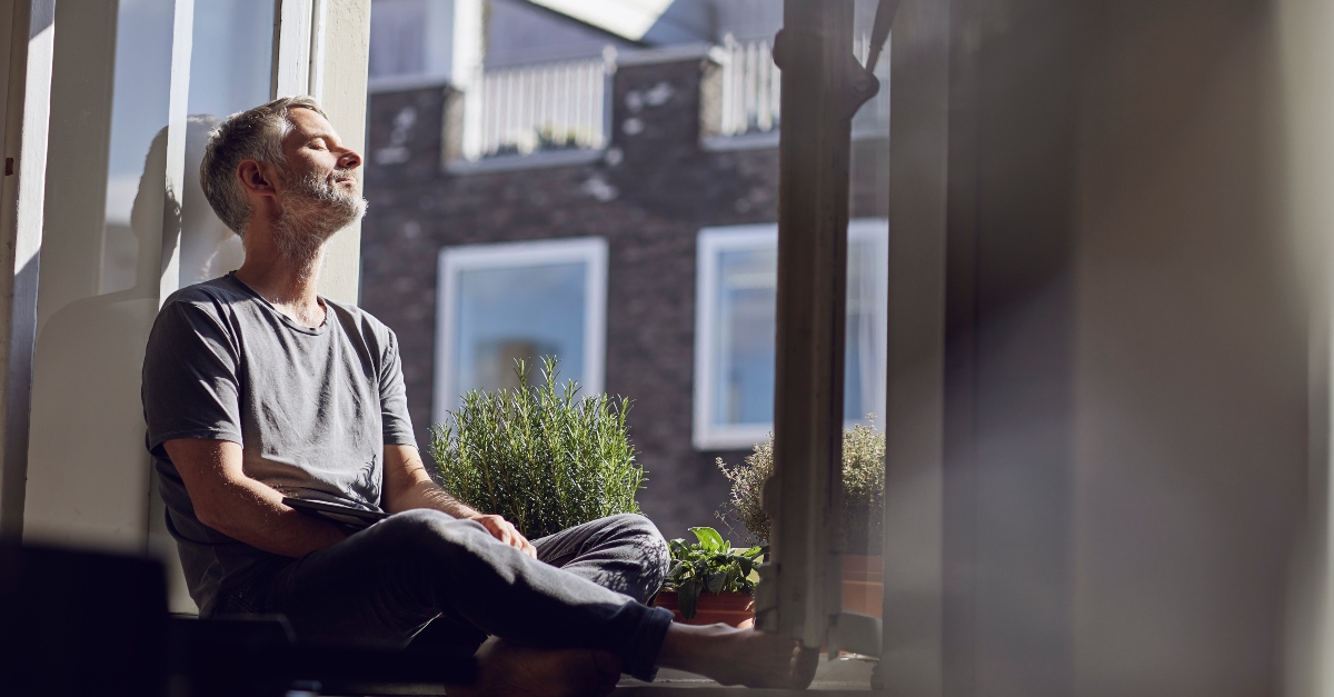 Older man sitting in a window seat relaxing