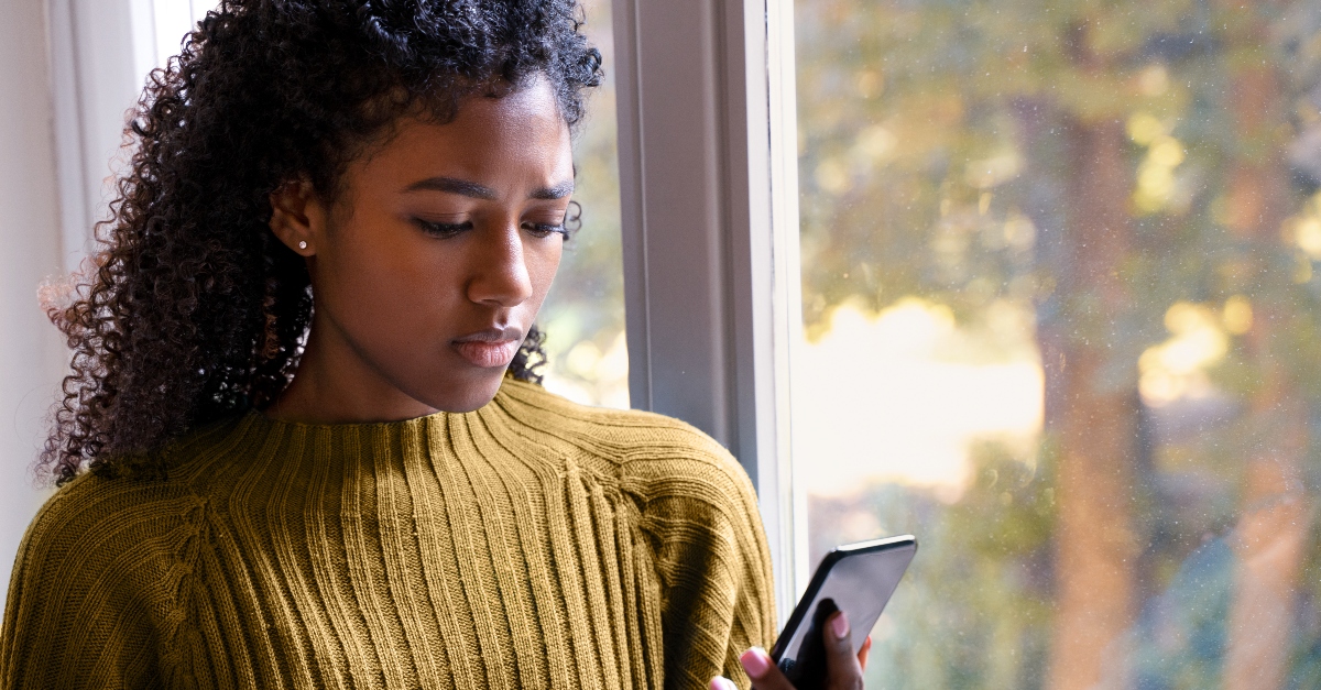 Woman looking at cell phone with jealousy