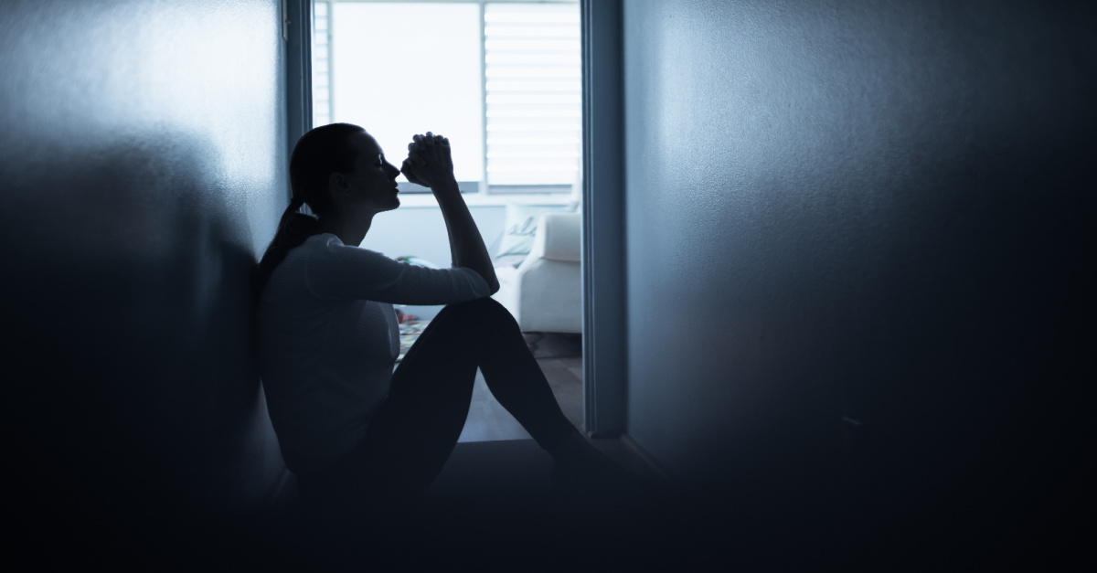 A woman praying in a hallway