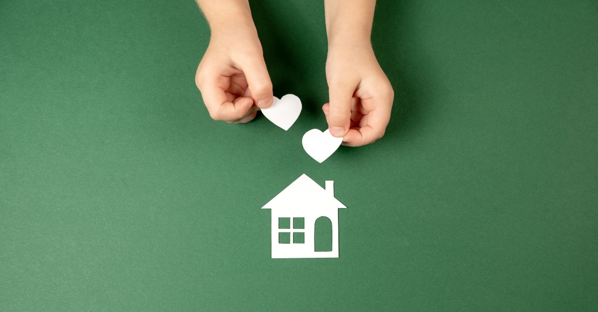 Child with a paper house and hearts
