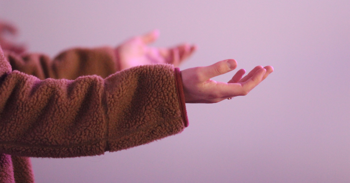 a women's hands out in worship