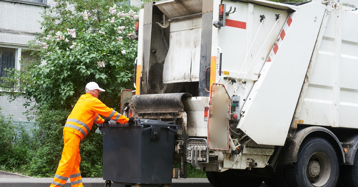 Garbage collector working at his truck