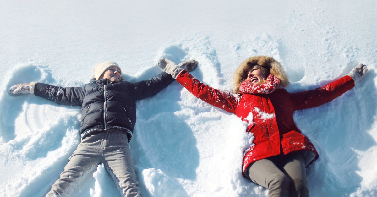 Mom and son making snow angels together