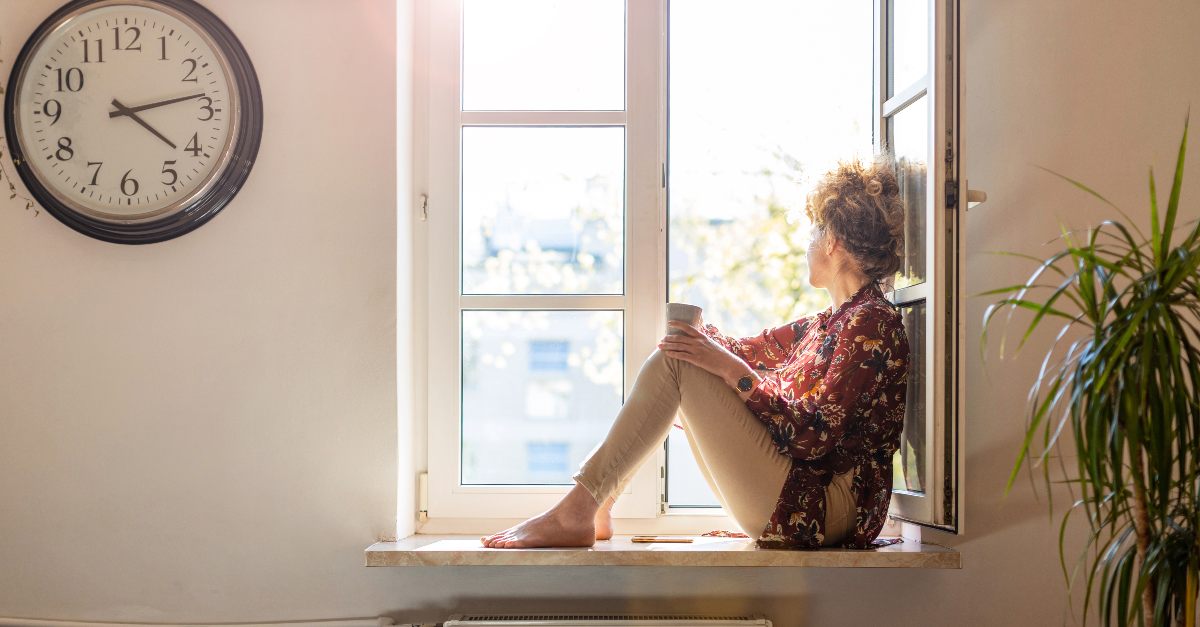 Woman sitting on her windowsill waiting