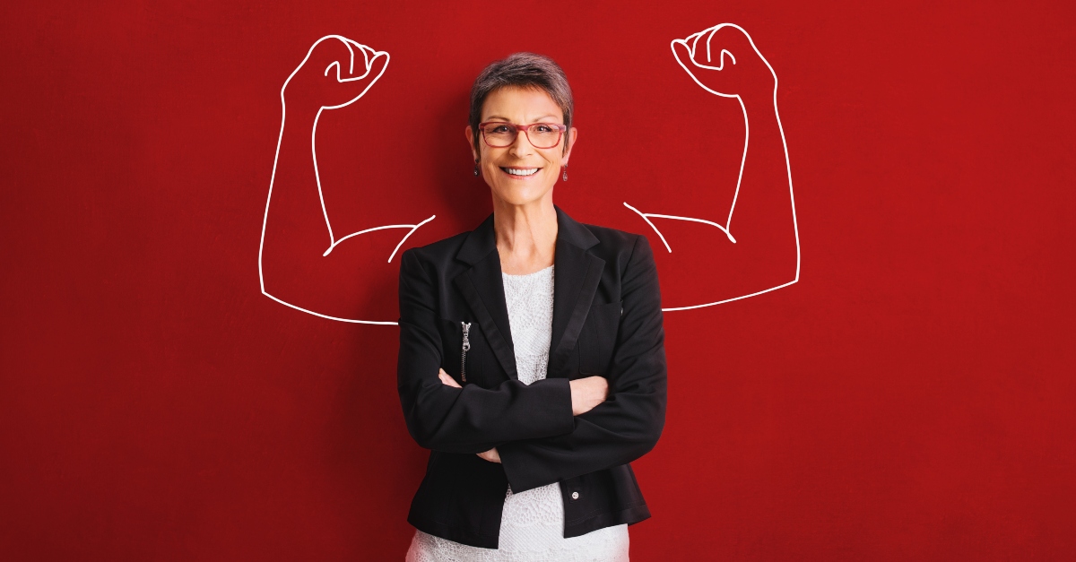 Happy woman standing in front of a wall with muscles drawn behind her