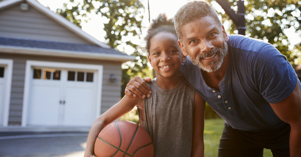 Dad with daughter playing basketball