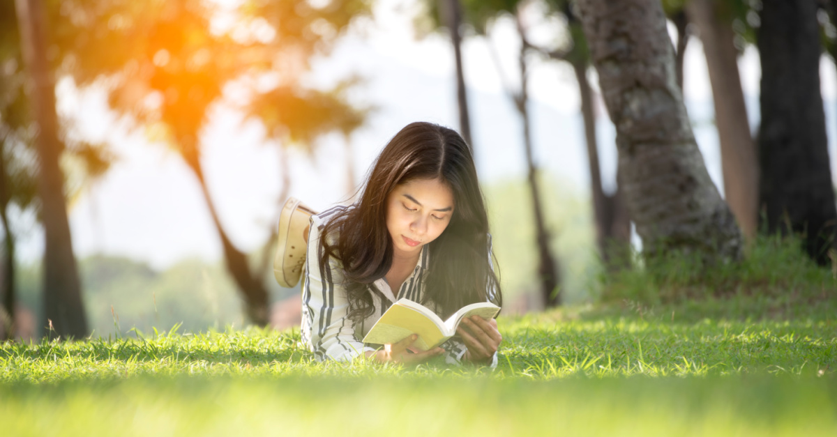 a girl reading in the grass
