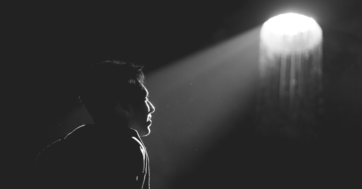 Black and white photo of a man looking towards the light