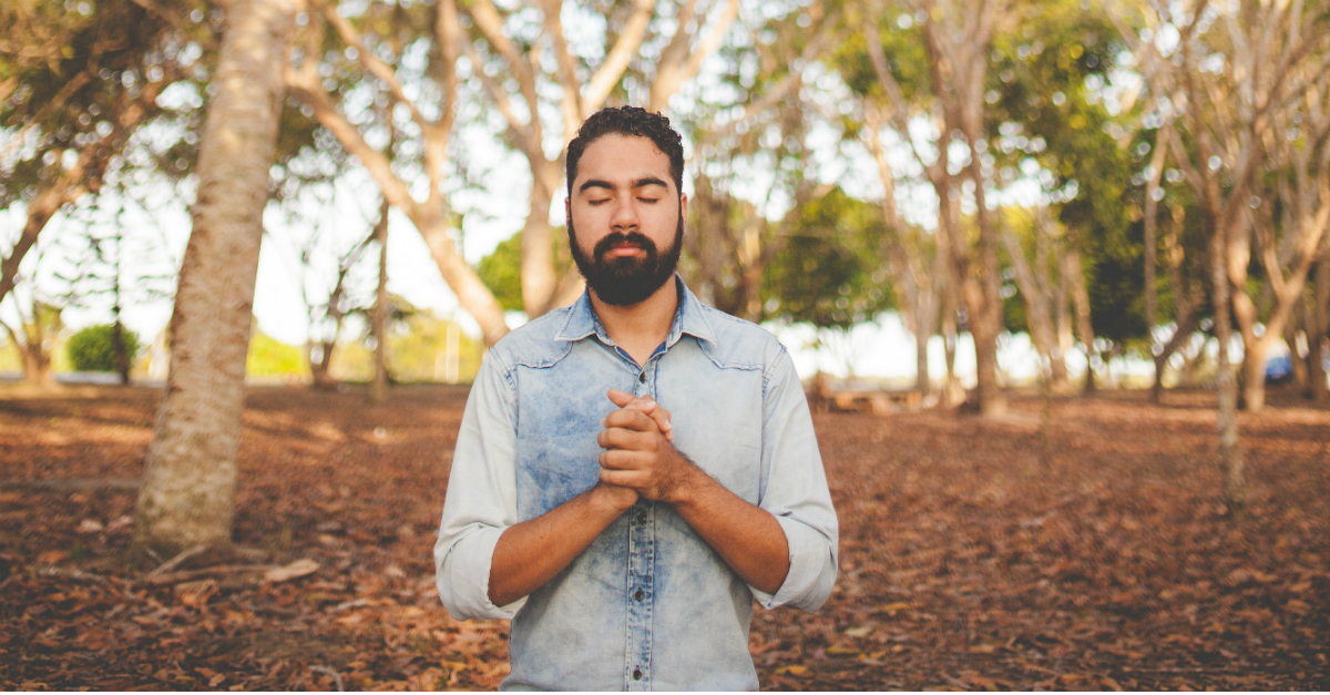 man praying with eyes closed outdoors because God answers prayer