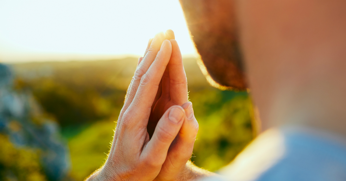 man praying outdoors for hedge of protection