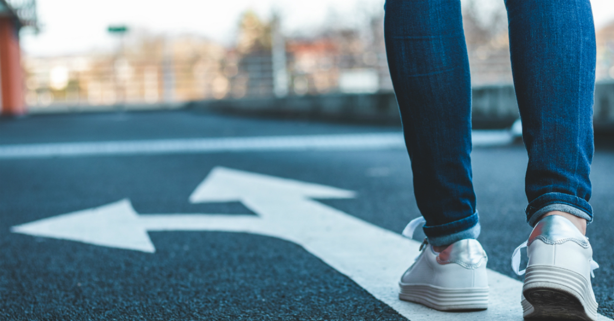 Woman walking on path, arrow pointing