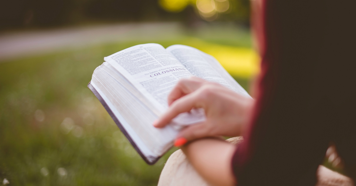 Woman reading Bible outside